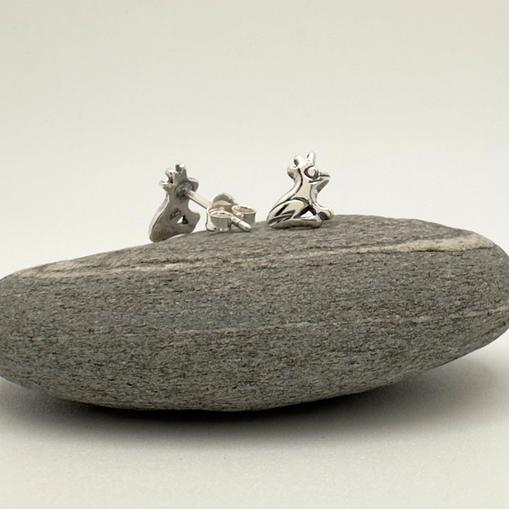 Silver earrings on a gray stone against a white background