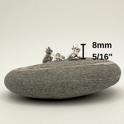 Small earrings on a stone with measurement text