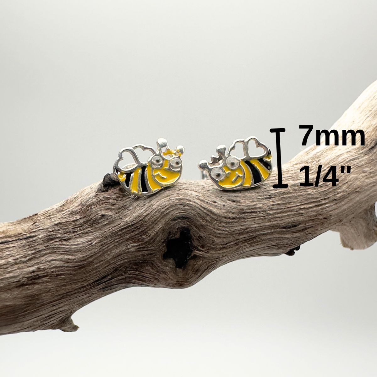 Bee-shaped earrings on a branch with measurement label