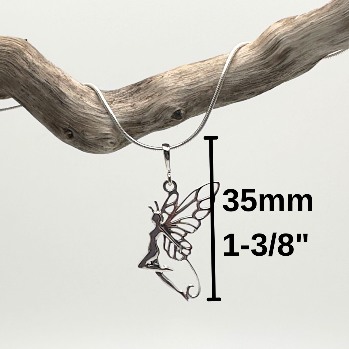 Silver fairy pendant on a branch with measurement details