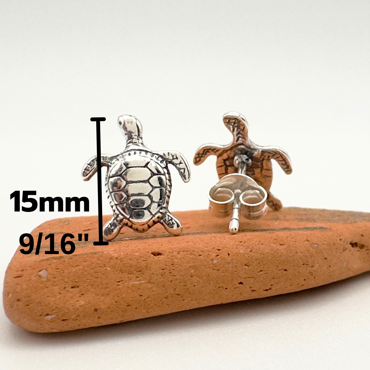 Turtle-themed earrings on a wooden stick with measurements indicated.