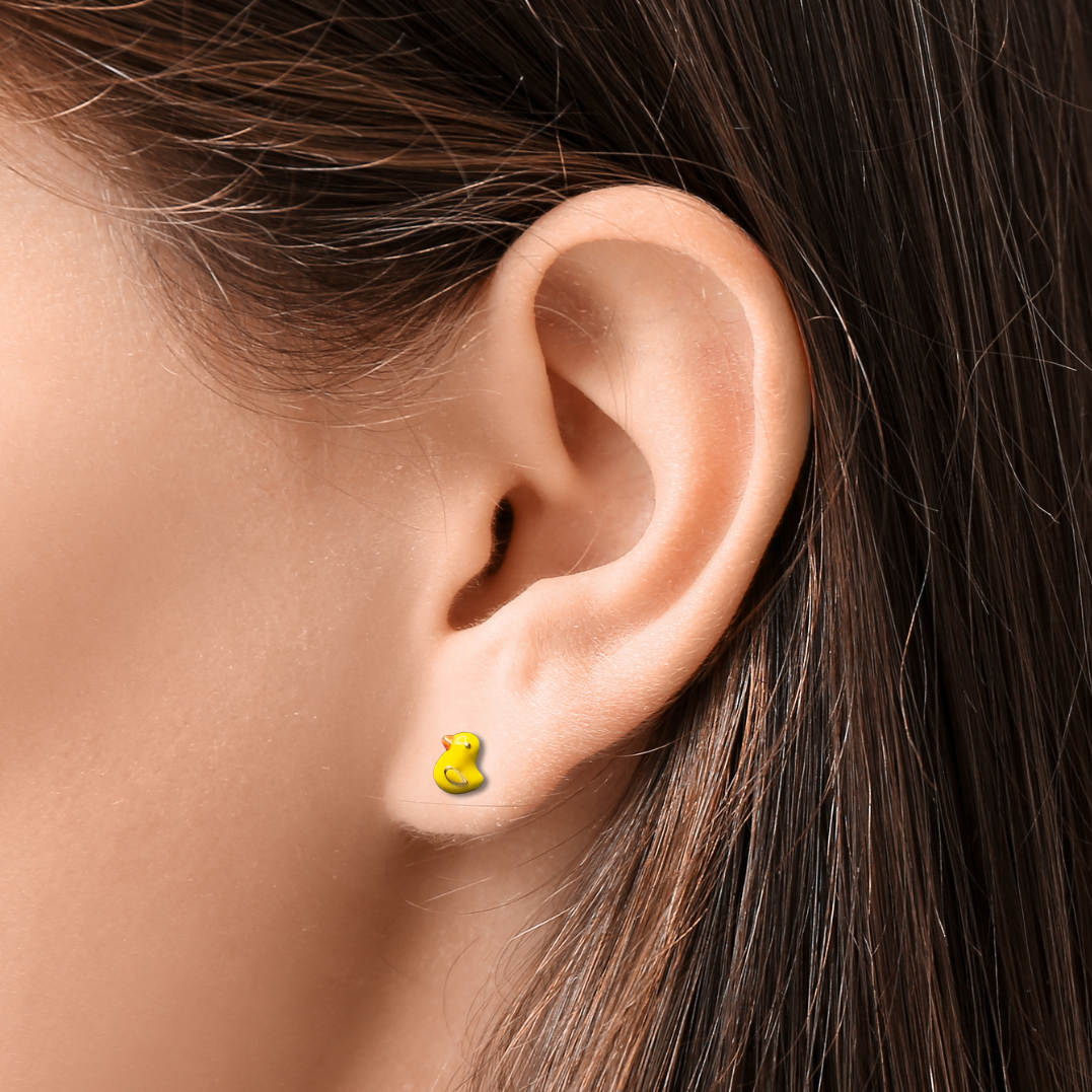 Close-up of an ear wearing a yellow earring with dark hair and skin background