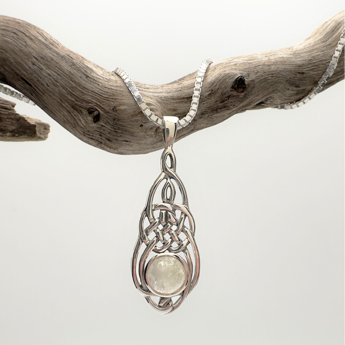 Silver pendant with a light-colored stone on a white background