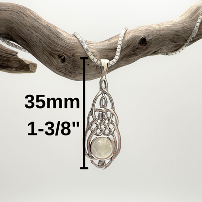 Silver pendant with measurement details on a branch