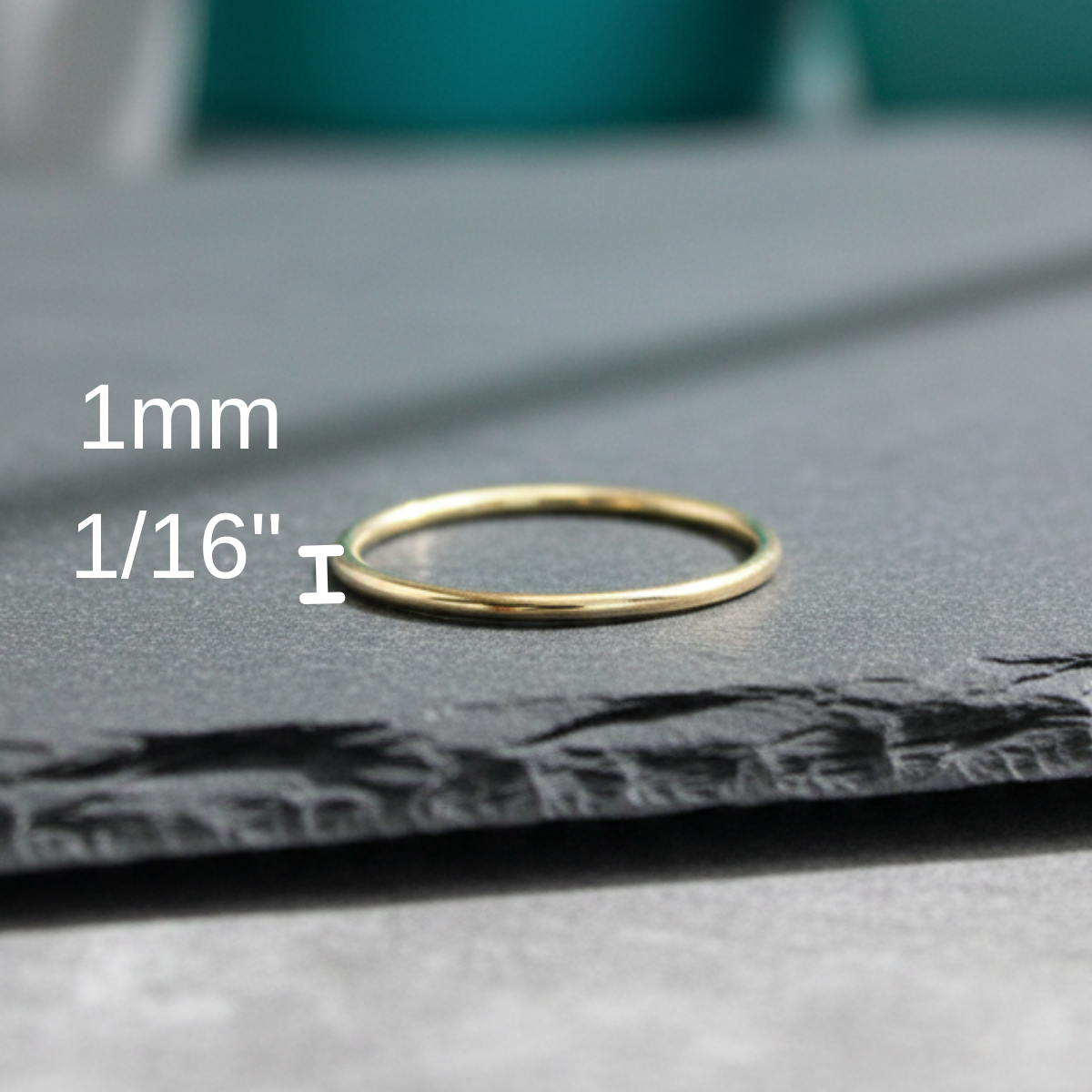 Gold ring on a gray surface with measurement text