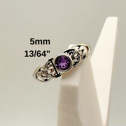 Silver ring with a purple gemstone on a white stand, showing size measurement.