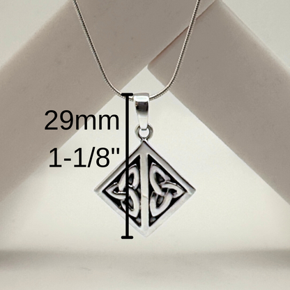 Silver pendant with measurement details on a beige background