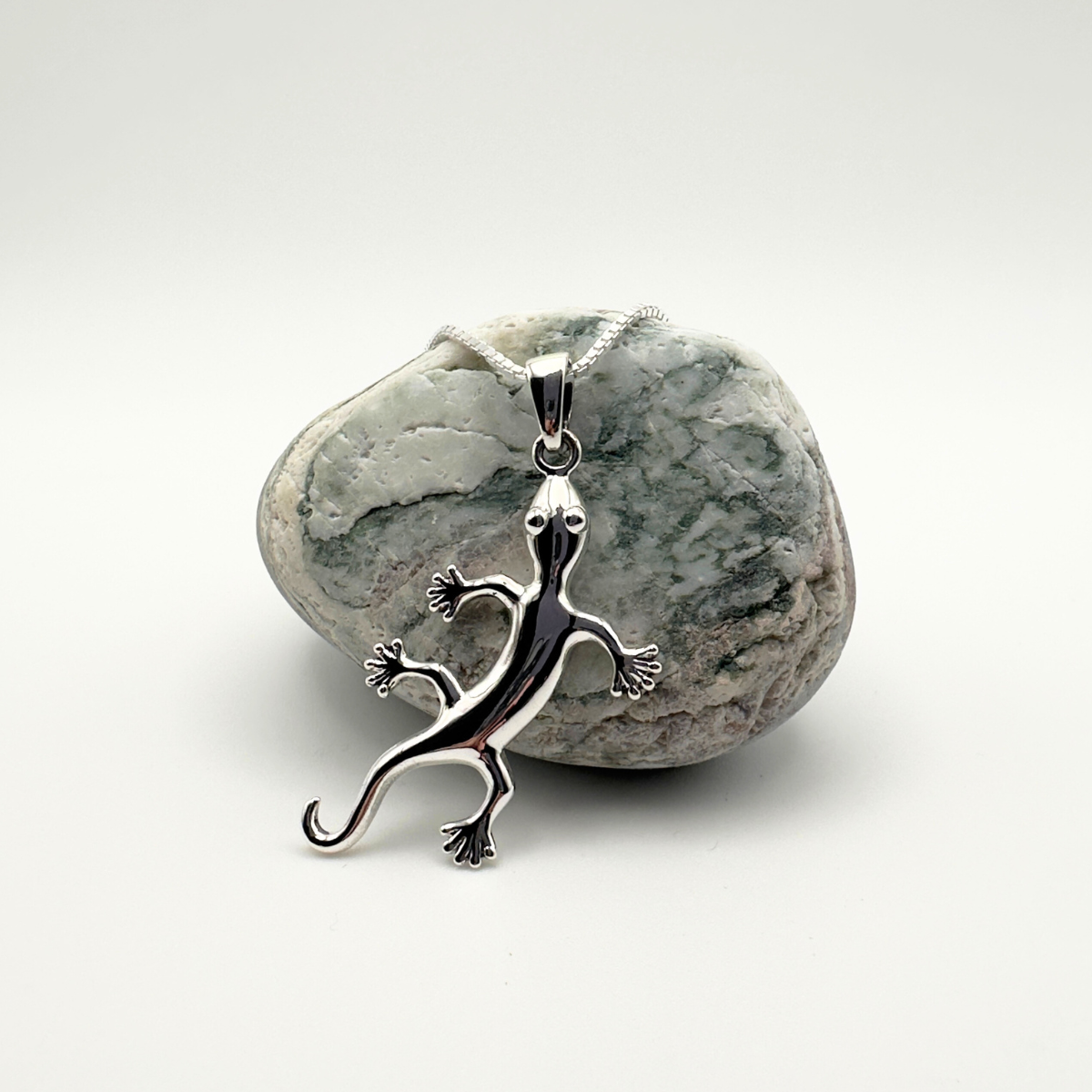 Silver lizard pendant on a white background