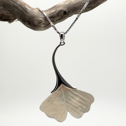 Necklace with a ginkgo leaf pendant on a branch against a white background