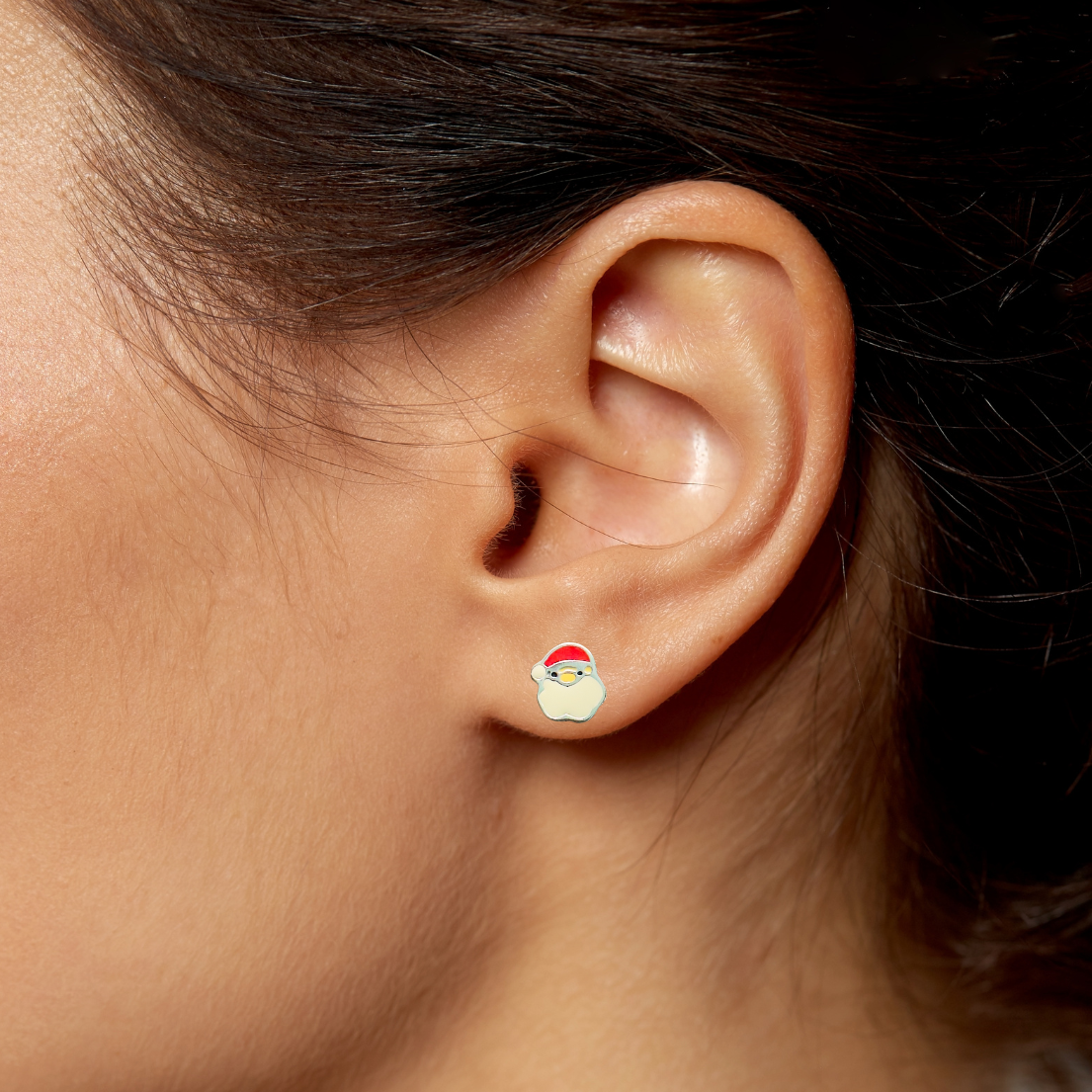 Close-up of an ear wearing a small santa face earring