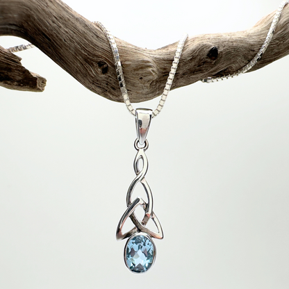 Silver pendant with a blue gemstone on a white background