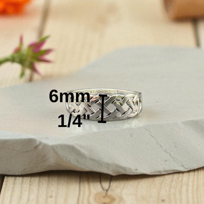 Silver woven ring on a stone surface with measurement text