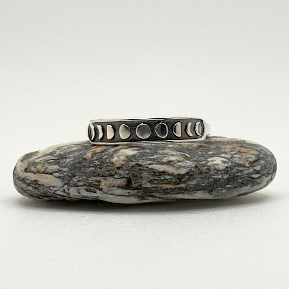 Silver ring with small stones on a textured stone surface
