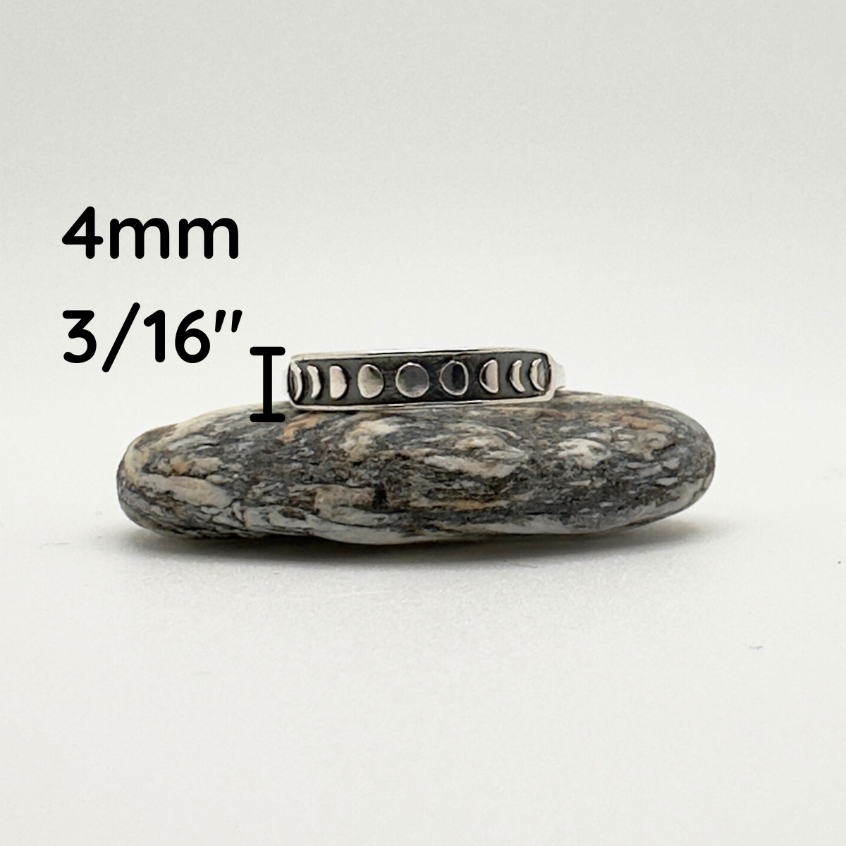 Silver ring on a rock with measurement text '4mm' and '3/16"'.