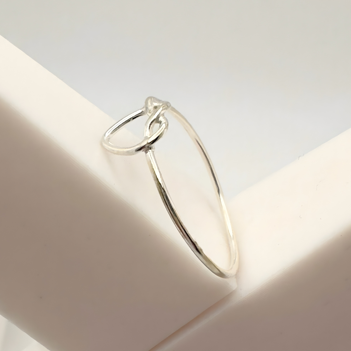 Silver ring on a white surface with a soft focus background