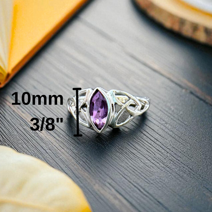 Silver ring with a purple gemstone on a dark surface, measurement label included.
